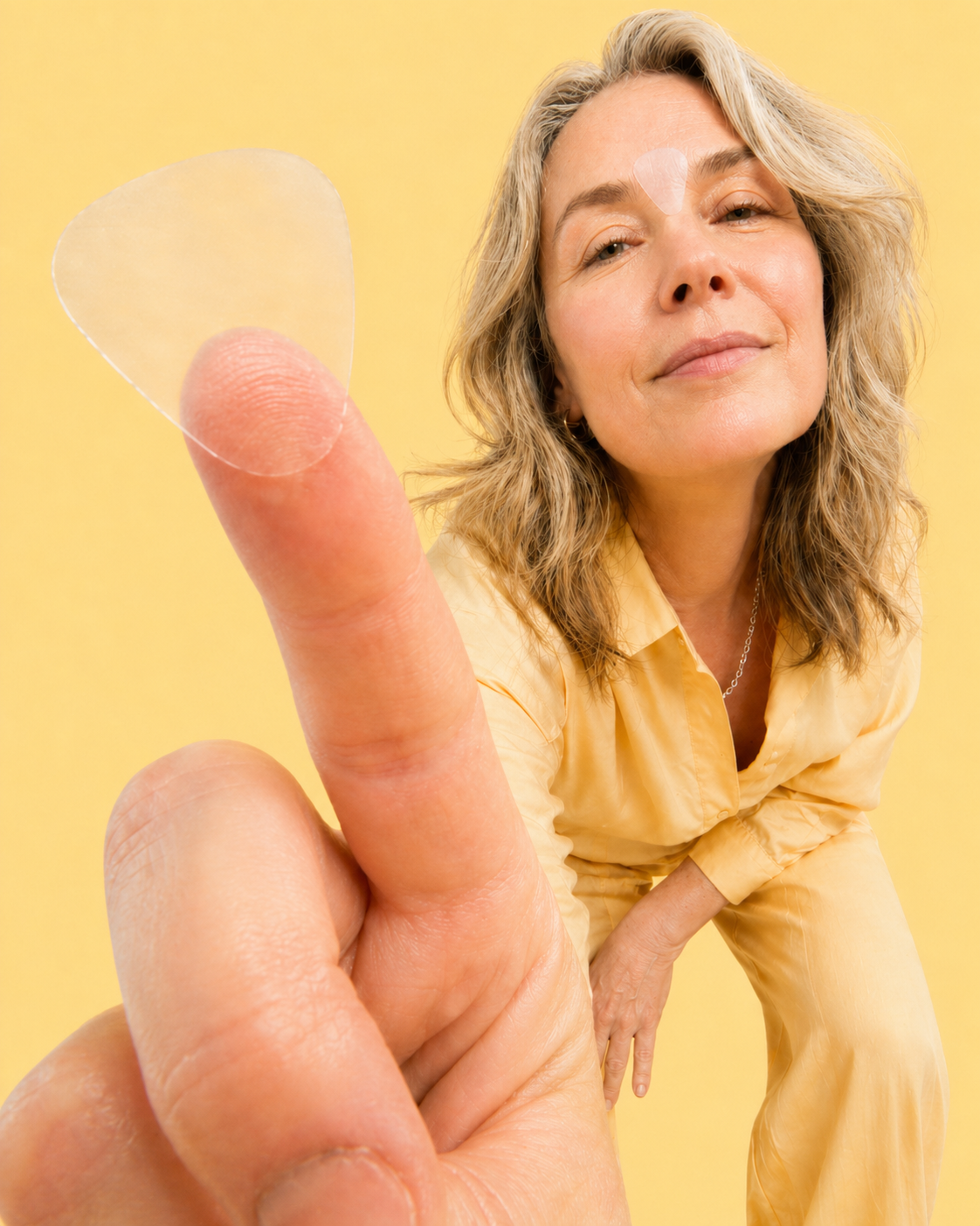 Woman with a large finger against a yellow background