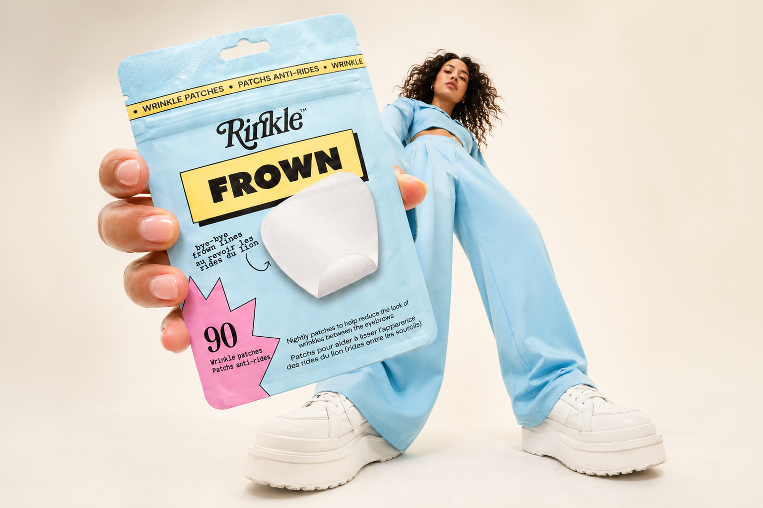 Person holding a RINKLE Frown product package against a plain background